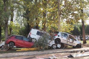 VALENCIA, SPAIN OCTOBER 31, 2024. Damaged vehicles piled up against a tree showing the devastating consequences of a recent flood in Valencia, Spain photo
