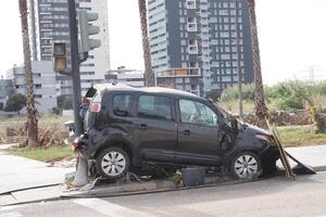 VALENCIA, SPAIN OCTOBER 31, 2024. Wrecked car leaning against a traffic light post, highlighting the devastating impact of the recent floods in Valencia photo