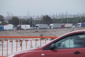 VALENCIA, SPAIN OCTOBER 31, 2024. Trucks are queuing on the highway near a flooded river in Valencia, Spain, showcasing the devastating impact of the floods photo
