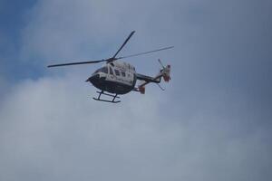 VALENCIA, SPAIN OCTOBER 31, 2024. Helicopter flying in cloudy sky during rescue operation in Valencia photo