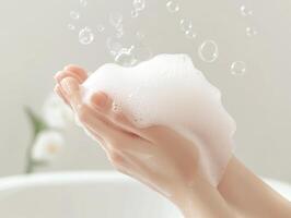 A person washing their hands with soap in a bathtub photo