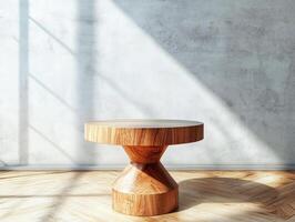 Wooden table with a round base in front of a wall photo