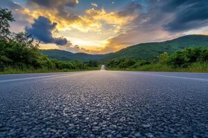 Natural scene at dawn with an asphalt road square, green mountain, and sky clouds photo
