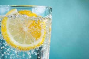A high-resolution image of a glass of sparkling water with lemon slices, showcasing vibrant bubbles and a clean background. Perfect for beverage advertisements and health-related products photo