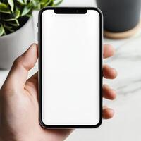 mockup of a blank white cell phone screen. texting while holding a mobile device at an office workstation. background void for advertising. work personnel in contact photo