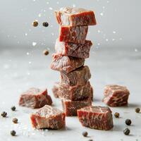 Levitating meat or beef cut pieces separated with black pepper and salt splash on white background in motion studio for advertisement photo