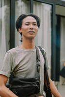 Southeast Asian man standing in front of a house with a relaxed expression photo