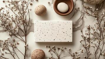 A white square with some eggs and a branch on a marble surface photo