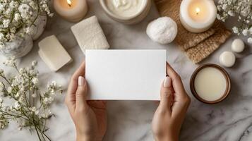 Woman's hands holding a blank paper with candles and spa products photo