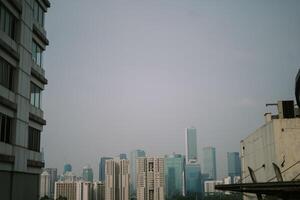 High-rise buildings and a major road in Jakarta city, with visible air pollution creating a hazy urban atmosphere photo