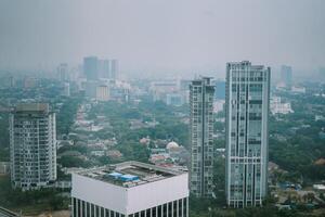 High-rise buildings and a major road in Jakarta city, with visible air pollution creating a hazy urban atmosphere photo