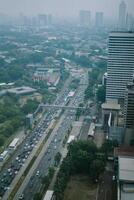High-rise buildings and a major road in Jakarta city, with visible air pollution creating a hazy urban atmosphere photo