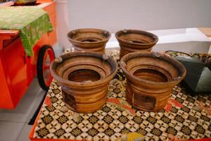 A traditional clay griddle for making surabi, showcasing its rustic design and earthy texture photo