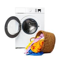 White Washing Machine With Open Door and Clothes Overflowing From a Wicker Basket photo