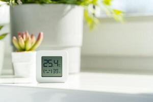 White Digital Thermometer Displaying Room Temperature and Humidity photo