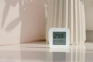 White Thermometer and Hygrometer on a White Surface With a Shadow photo