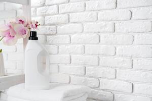 Laundry Detergent Bottles and Stacked Towels On Top of a Washing Machine photo
