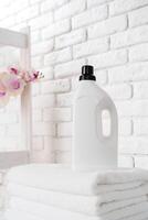 Laundry Detergent Bottles and Stacked Towels On Top of a Washing Machine photo