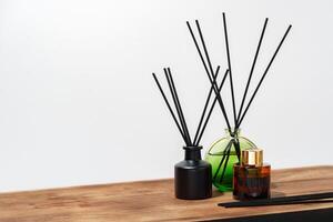 Black And Brown Glass Reed Diffuser Bottles On Wooden Surface photo