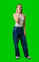Young Woman Gesturing Silence In Front of a Green Screen photo
