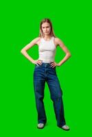 Young Woman Standing With Hands on Hips Against Green Screen photo
