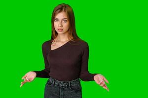 Young Woman Shrugging Her Shoulders in Front of Green Screen photo
