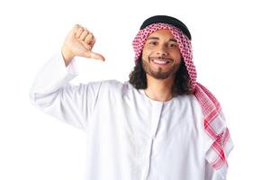 Young Arab man in traditional clothing pointing on himself on white background photo