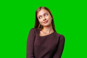 Young Woman Looking Up and to the Right in Front of a Green Screen photo