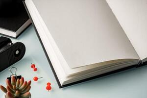 Open notepad and red pushpins on the table photo