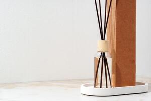 Reed Diffuser Bottle With Wooden Sticks on White Tabletop photo