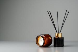 Amber Glass Candle and Reed Diffuser on Grey Surface photo
