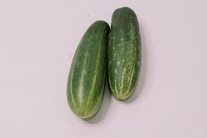 Fresh cucumbers arranged on a clean white background, highlighting their crisp texture and vibrant green color, photo