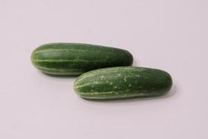 Fresh cucumbers arranged on a clean white background, highlighting their crisp texture and vibrant green color, photo