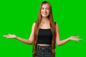 Smiling Young Woman With Open Palms Gesturing On Green Screen photo