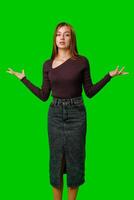 Young Woman Gesturing With Open Palms in Front of Green Screen photo
