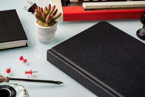 Notebook and feather pen on working table photo