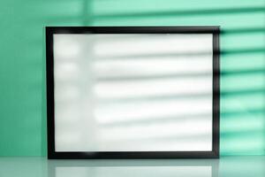 Black frame mock up against mint background with shadow photo