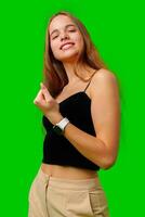 Young Woman Celebrating Success With Raised Fists Against Green Screen Background photo