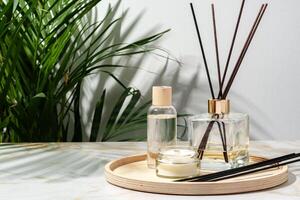 Black Reed Diffuser, Amber Candle, and Wooden Tray on White Surface photo