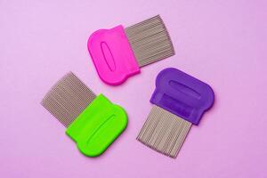 Three combs for removing lice and nits on lilac background photo
