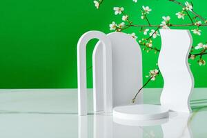 Decorative podiums and blooming branches on green background with shadows photo