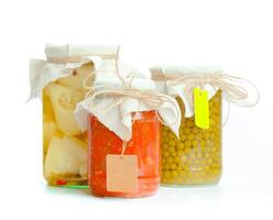 Canned vegetables in glass jars isolated on white background photo