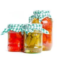 Canned vegetables in glass jars isolated on white background photo