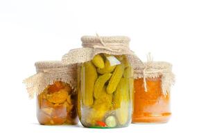 Canned vegetables in glass jars isolated on white background photo