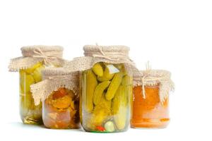 Canned vegetables in glass jars isolated on white background photo