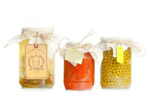 Canned vegetables in glass jars isolated on white background photo