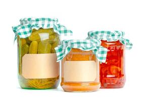 Canned vegetables in glass jars isolated on white background photo