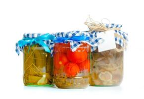 Canned vegetables in glass jars isolated on white background photo