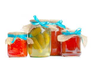 Canned vegetables in glass jars isolated on white background photo