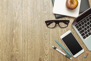 Office table with smartphone on it. View from above photo
